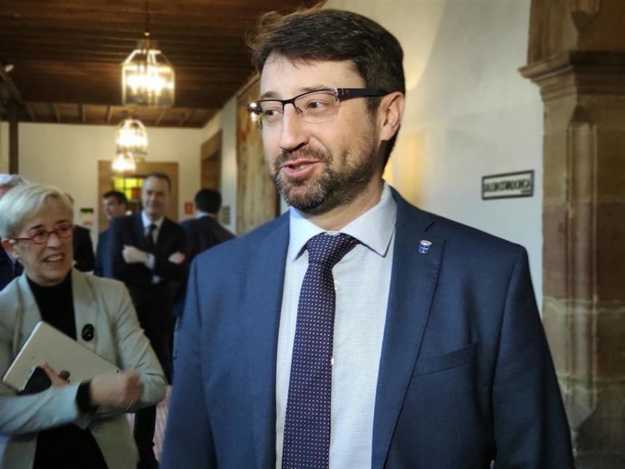 El consejero de Industria, Empleo y Promoción Económica, Enrique Fernández, atiende a los medios en un jornada de internacionalización con la directora de Asturex, Teresa Vigón, en segundo plano.