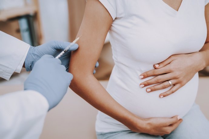 Mujer embarazada recibiendo una vacuna.