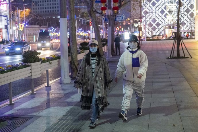 Dos mujeres se protegen con mascarillas del nuevo brote de coronavirus en Shanghai.
