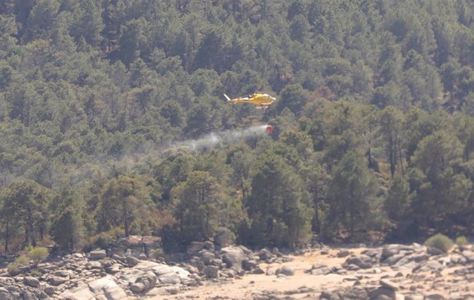 Un helicóptero recoge agua del pantano de Burguillos, Ávila para extinguir un fuego.