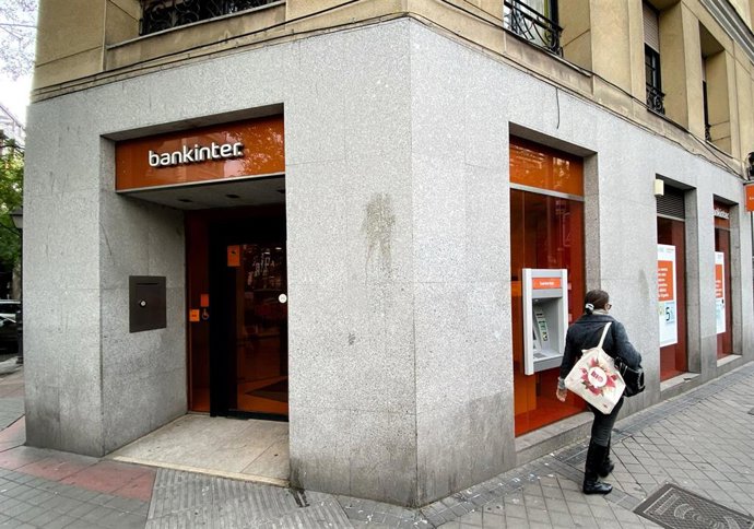 Una mujer camina junto a una oficina del Bankinter en Madrid.
