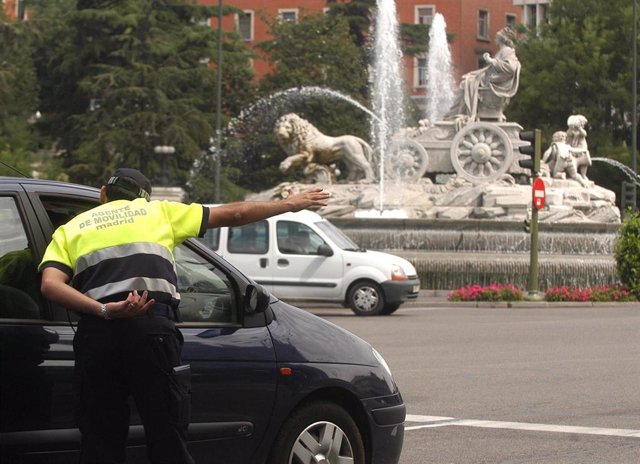 Un agente de movilidad del Ayuntamiento de Madrid da indicaciones a un conductor en la Plaza de Cibeles.