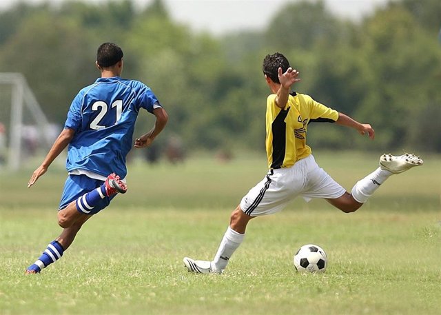 Jugar al fútbol.