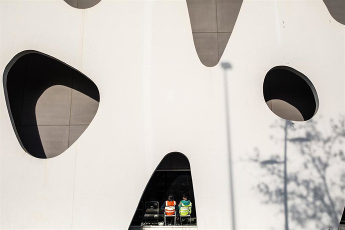 Dos trabajadores descansan sentados en sillas en el pabellón del Mobile World Congress (MWC) durante el desmantelamiento de los stands de la feria tras la cancelación de la mism, en Barcelona/Catalunya (España) a 13 de febrero de 2020.