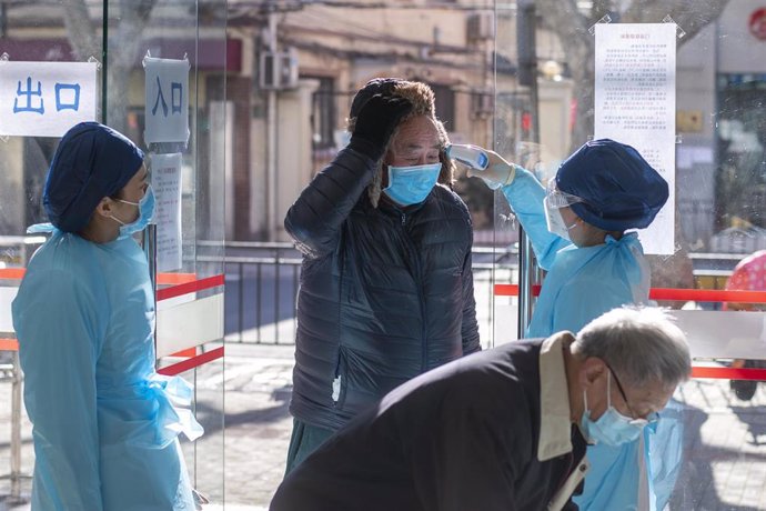 Un hombre es sometido a una prueba de temperatura en Shanghái (China) a causa del brote de nuevo coronavirus