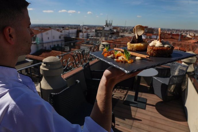 Un camarero lleva una bandeja con dos toriijas del chef Juan Manuel Muñoz, en la terraza del Hotel Catalonia (Calle Atocha 8).   
