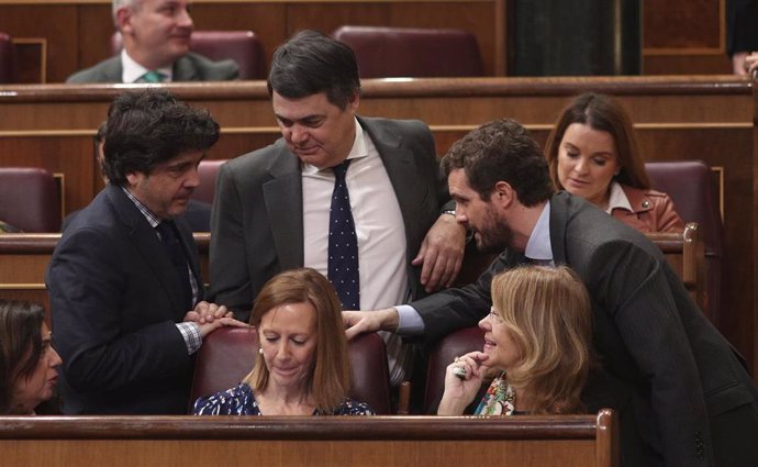 El presidente del PP, Pablo Casado (dech), habla con algunos de los diputados de su partido durante una sesión de control al Gobierno en el Congreso de los Diputados, Madrid (España), a 19 de febrero de 2020.