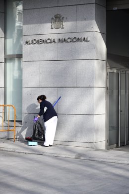 Una trabajadora de la lipieza barre la puerta pricipal de la sede de la Audiencia Nacional de Madrid.