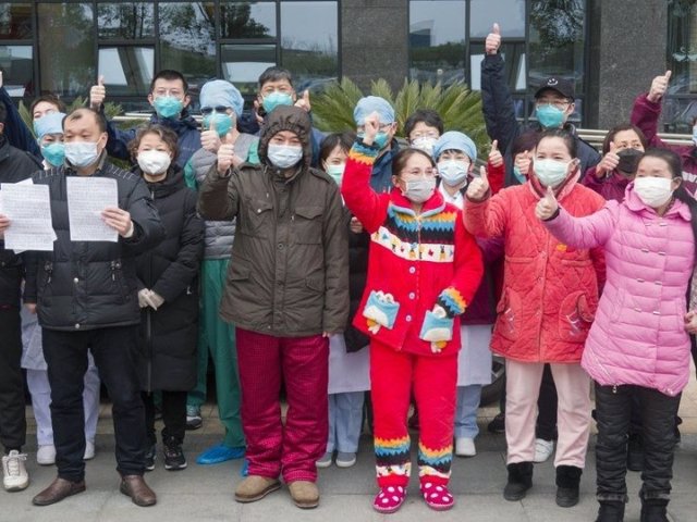 Los pacientes recuperados de neumonía por coronavirus novedosa  posan para fotos con el personal médico en el campus oeste del Hospital Wuhan Union en Wuhan, provincia de Hubei, en China central, el 19 de febrero de 2020.