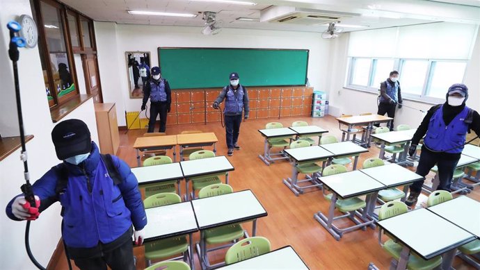 Operarios desinfectan un aula en la ciudad surcoreana de Suwon.
