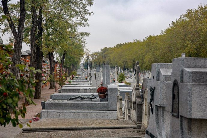 Una cesta con flores sobre una lápida en el Cementerio de La Almudena de Madrid.
