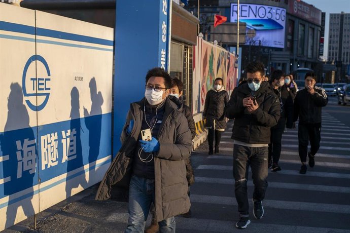Ciudadanos caminan con mascarillas por una calle de Shanghái