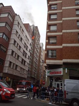 Los bomberos sofocando un fuego en un piso en Gijón