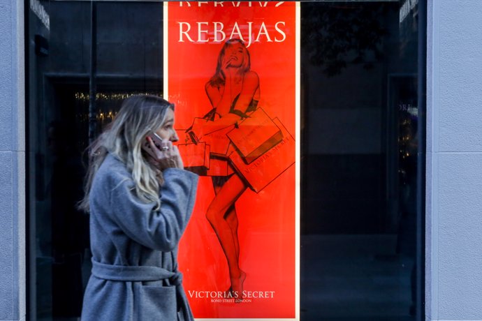 Una mujer pasea junto a la tienda de Victoria Secret en la Calle Fuencarral de Madrid, donde ya ha empezado la temporada de rebajas.