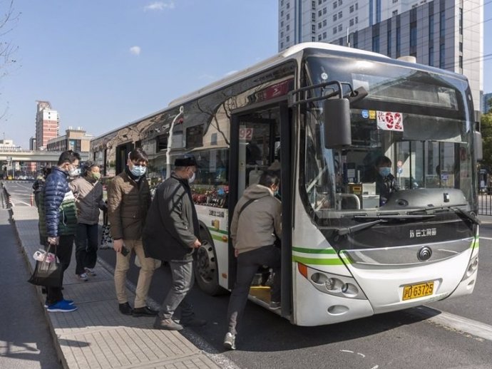 Los pasajeros con máscaras se suben a un autobús en una estación de autobuses en Shanghai, este de China, el 17 de febrero de 2020.