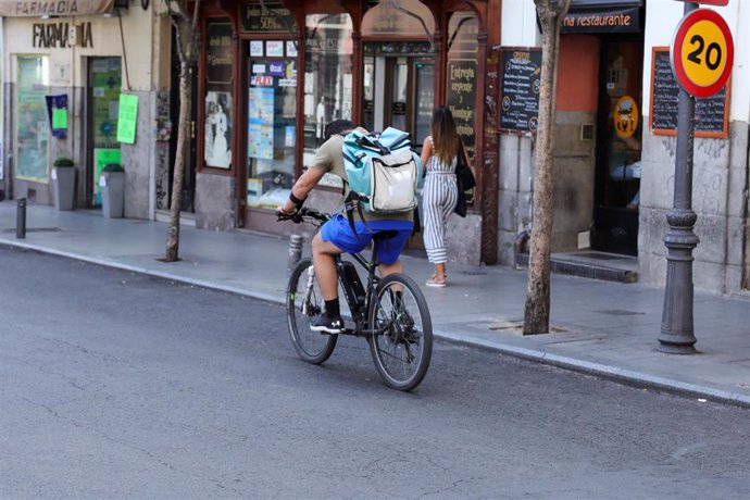 Fotografía de un repartidor de la empresa de reparto Deliveroo transitando en bicliceta por una calle del centro de Madrid.