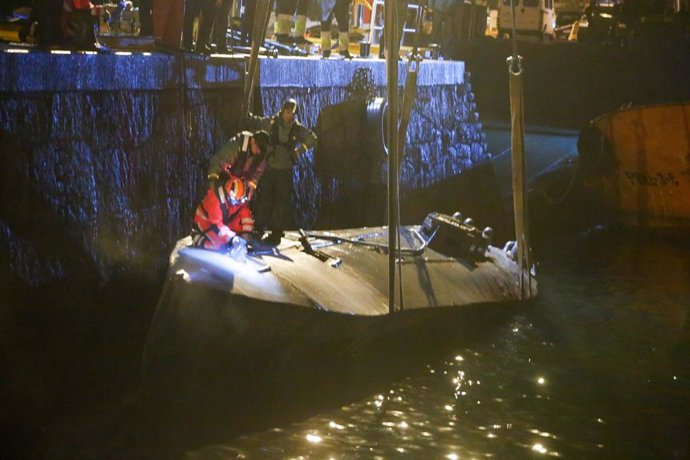 Agentes de la Policía y de la Guardia Civil subidos en el narcosubmarino hundido el pasado fin de semana a la entrada de la ría de Aldán, en Cangas (Pontevedra) en el momento en el que estaba siendo reflotado por dos grandes grúas. Se trata del primer n