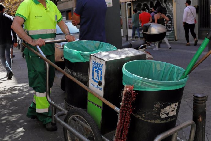 Un barrendero del Ayuntamiento de Madrid, empuja su carro de la limpieza mientras trabaja en una calle del centro de la ciudad.