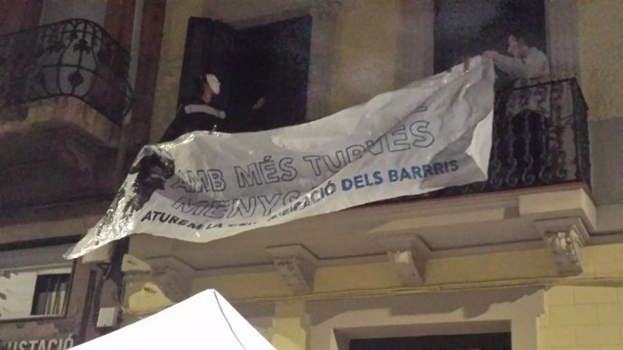 Els activistes colloquen una pancarta la nit d'aquest dissabte en una balconada de l'edifici després d'ocupar-lo.