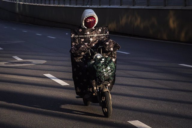 Una mujer en moto por las calles de la ciudad de Wuhan, epicentro del nuevo brote de coronavirus