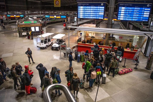 24 February 2020, Bavaria, Munich: Travellers line up at the Deutsche Bahn information desk after a train was stopped at the Brenner Pass for Coronavirus suspicion. Photo: Lino Mirgeler/dpa
