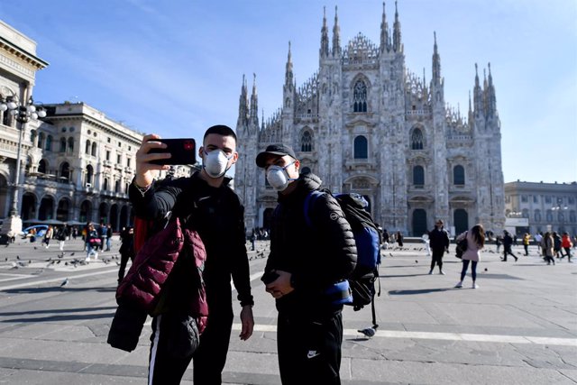 24 February 2020, Italy, Milan: Two tourists take a selfie while wearing surgical masks in front of the Duomo vaig donar Milano amid the outbreak of the coronavirus. Photo: Claudio Furlan/LaPresse via ZUMA Press/dpa