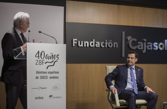 El presidente de la Junta de Andalucía, Juanma Moreno (d), junto al director general de la Cadena Ser (i), durante su intervención en el ciclo organizado por la Cadena SER sobre los 40 años de la autonomía andaluza