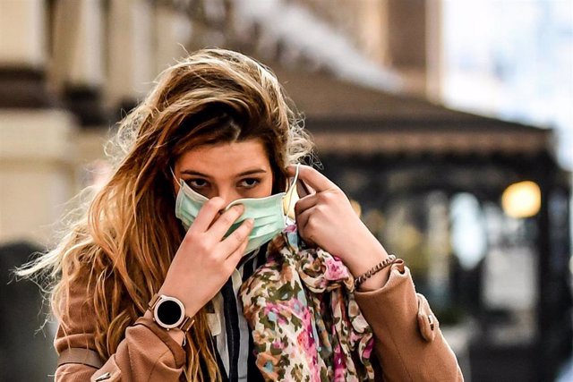 Una joven se coloca una máscara en Milán tras la alerta por el coronavirus.