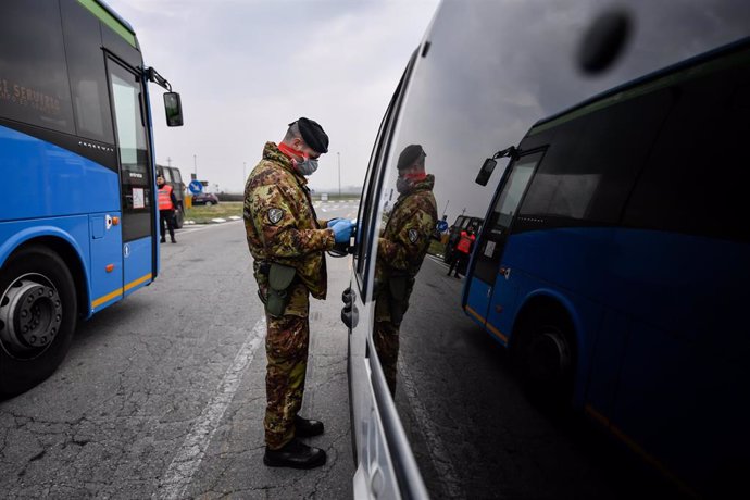 25 February 2020, Italy, Turano Lodigiano: An Italian army soldier with a surgical mask inspects the licence of a driver at a check point amid the outbreak of the coronavirus. Photo: Claudio Furlan/LaPresse via ZUMA Press/dpa