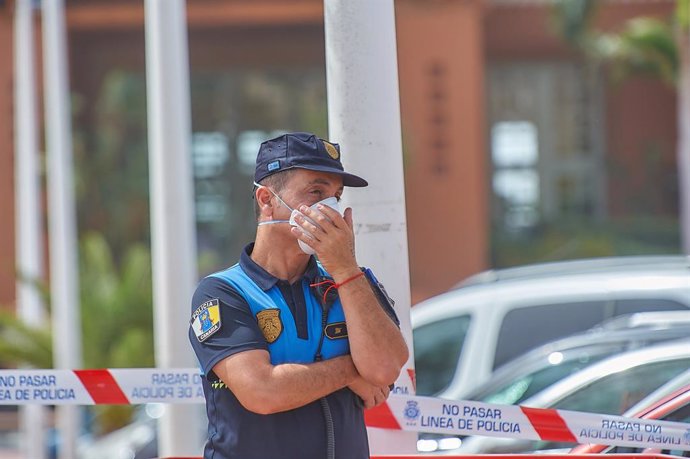 25 February 2020, Spain, Adeje: A Spanish police man wears a mouth mask as he stands guard in front of the H10 Costa Adeje Palace hotel after an Italian tourist tested positive for contraction with coronavirus. Photo: Tony Cuadrado/CONTACTO/dpa