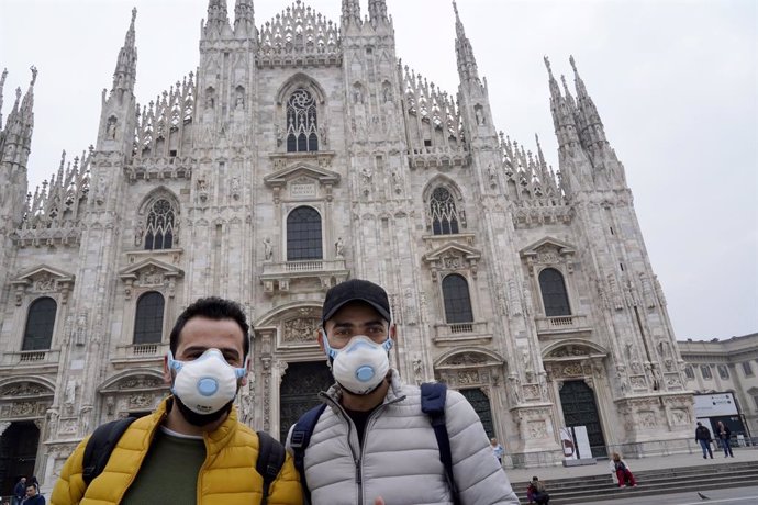 February 25, 2020 - Milan, Italy: Tourists wearing a protective face mask pose for a picture in front of Milan landmark, the Duomo Cathedral. (Lucia Sabatelli/Contacto)