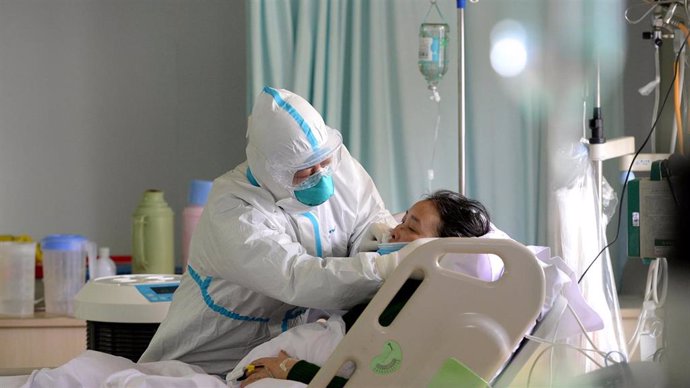 Un médico militar atiende a un paciente enfermo de coronavirus en la unidad de cuidados intensivos, en China.