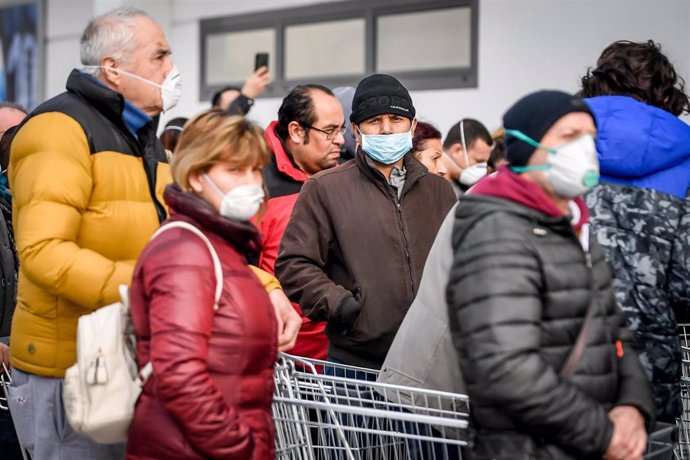 23 February 2020, Italy, Casalpusterlengo: People with surgical masks queue in front of a supermarket for supplies in an area where the spread of the coronavirus has been detected. Photo: Claudio Furlan/LaPresse via ZUMA Press/dpa