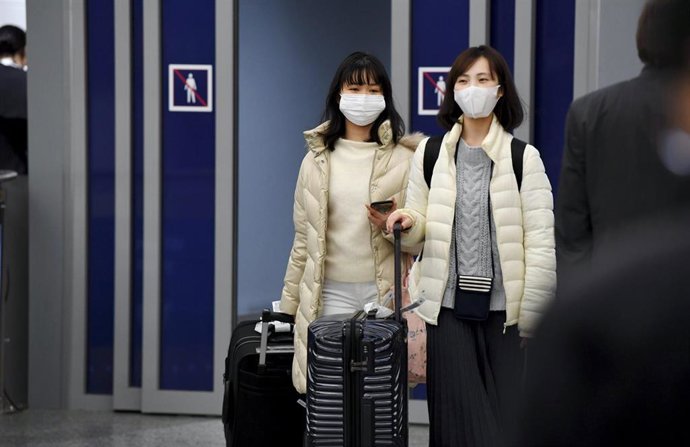 Pasajeros asiáticos con mascarillas a su llegada a un aeropuerto en Finlandia