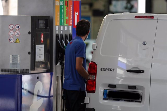 Personas ponen gasolina en sus coches en una gasolinera de Madrid.