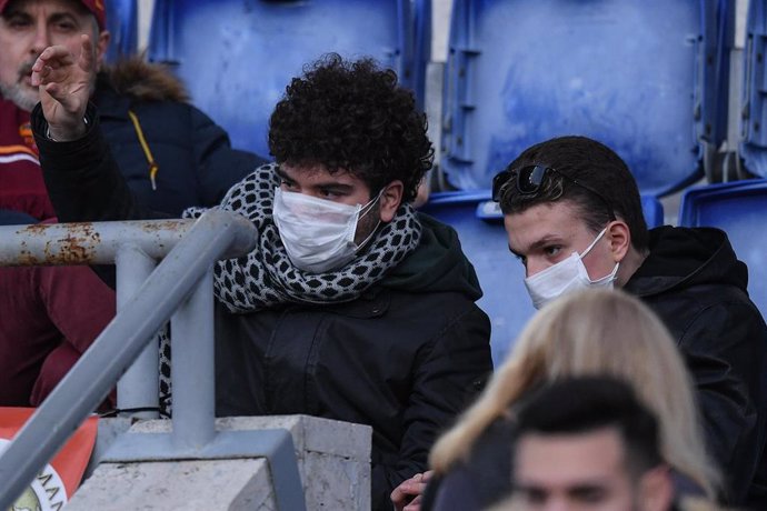 Dos aficionados de la AS Roma, con máscaras.