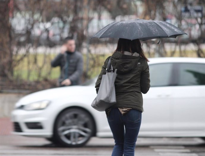 Una mujer pasea con paraguas para protegerse de la borrasca `Gloria que deja fuertes lluvias en la capital, en Madrid (España), a 24 de enero de 2020.
