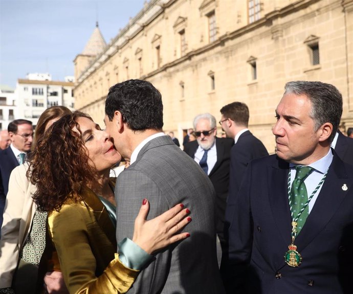 La ministra de Hacienda, María Jesús Montero, saluda al presidente de la Junta, Juanma Moreno, en el acto del Parlamento por el 28F.