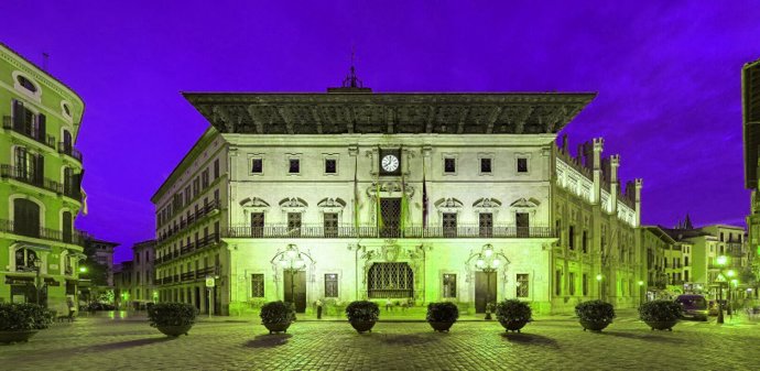 La fachada del Ayuntamiento de Palma iluminada de color verde.