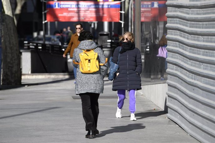 Tres personas caminan por Madrid con la presencia de la borrasca Jorge que desde el sábado se hace notar en la península dejando rachas muy fuertes de viento, lluvias y un frente frío, en Madrid (España), a 2 de marzo de 2020.