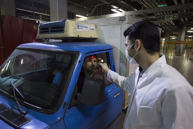 Un trabajador médico de Irán comprueba la temperatura de un hombre en Teherán ante el brote de nuevo coronavirus