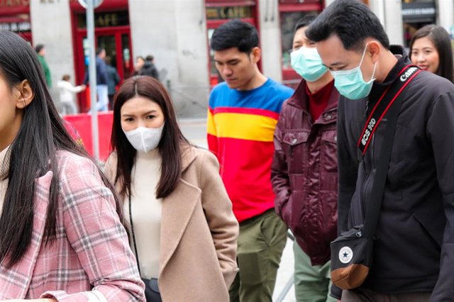 Recursos de transeúntes por el centro de Madrid con mascarillas tras el anuncio de casos de coronavirus en España