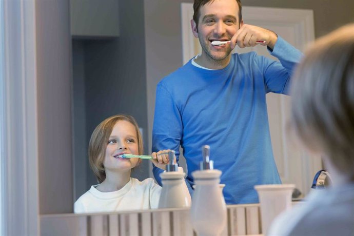Padre y niño limpiándose los dientes. Higiene dental. Cepillarse los dientes.