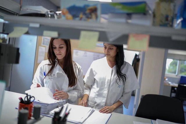 Dos trabajadoras leen unos informes. 