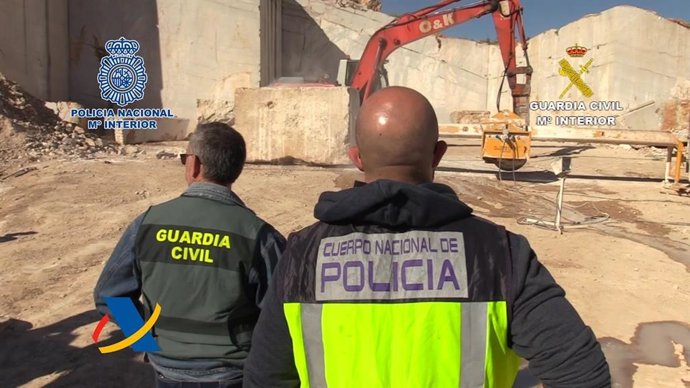 Agentes de Guadia Civil y de la Policía Nacional observando los bloques de mármol en los que se transportaba la droga