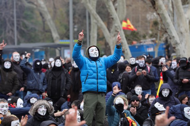 Manifestantes con máscaras de Anonymous y banderas de España se concentran en la plaza de Neptuno.