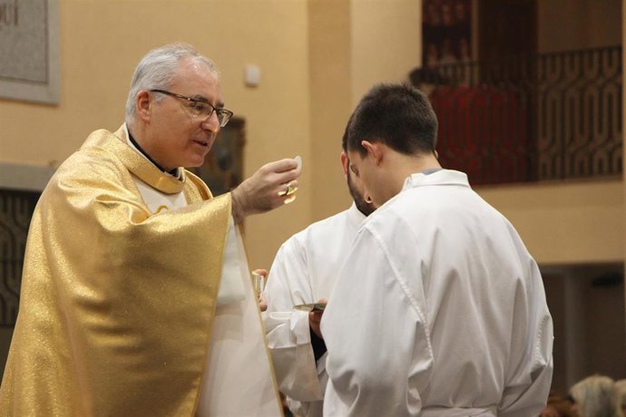 El obispo auxiliar de la Diócesis de Cartagena, Sebastián Chico, ofrece el Cuepro de Cristo a un feligrés