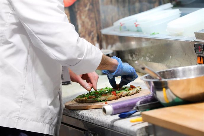 Un cocinero prepara una pizza, en Madrid (España) a 24 de febrero de 2020.