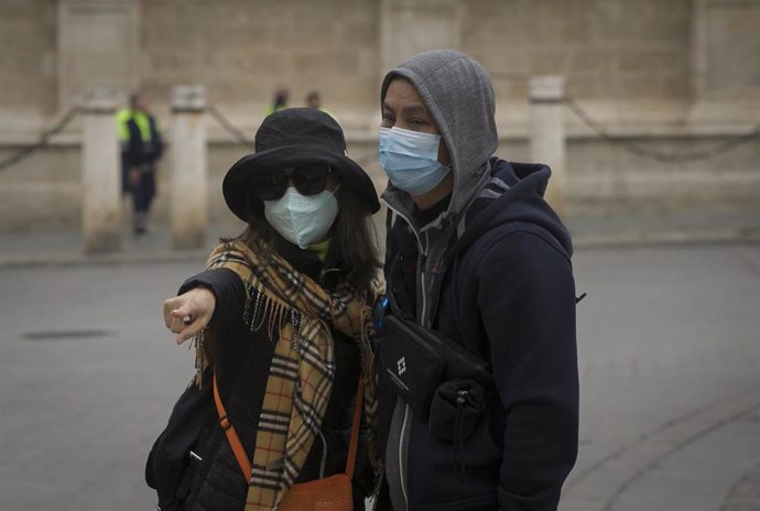 Dos turistas con mascarillas para evitar el contagio por coronavirus. 