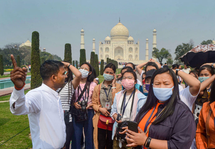 03 March 2020, India, Agra: Tourists wear protective masks during their tour at Taj Mahal. Photo: Pawan/PTI/dpa